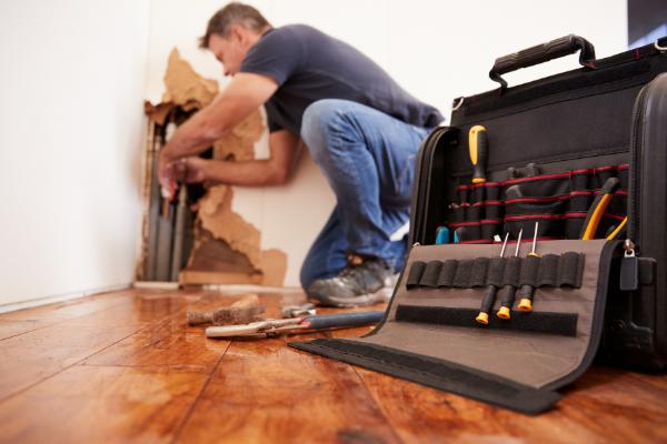 plumber fixing plumbing with toolbag